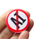 A round white button that reads NO AI (Artificial Intelligence) in black text with a red circle and slash to indicate being against billionaires. Badge is held in a hand.