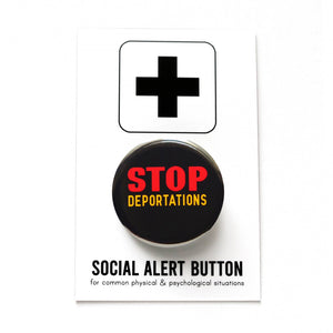 Round black pinback button that reads: STOP DEPORTATIONS in red and yellow text. Button is held in a hand.