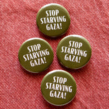 Four round olive green pinback buttons that read STOP STARVING GAZA! in white text. The buttons are pinned to orange denium.