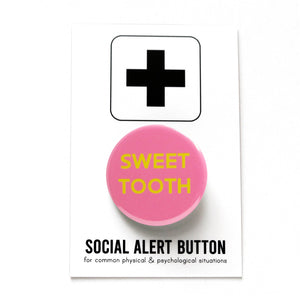 Round vibrant pink pinback button reading SWEET TOOTH in yellow text. Pinned to a Social Alert Button backing card.