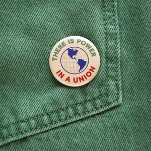 There is Power In a Union Pinback Button on green denim pocket.