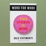 Big 3-inch shiny deep pink pinback button with bright yellow and red chunky san serif text that reads: This Uterus is Mine. Smaller text in a green runs in a circle around the permitter that says Fuck Off Alito, Fuck Off Thomas, Fuck Off Coney-Barrett, Fuck Off Gorsuch, Fuck Off Kavanaugh.