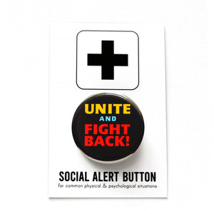 A round black pinback button that reads UNITE AND FIGHT BACK! in yellow, blue and red type. Button is held in a hand.