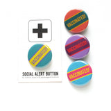 Mixed color pinback buttons that read VACCINATED in a diagonal block across the middle
