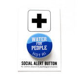 A round blue 1.25" pinback button that reads WATER FOR PEOPLE, NOT AIin 2 different white fonts. The pinback button is attached to a SOCIAL ALERT BUTTON backing card. 