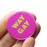 Round 1.25" pinback button with bright magenta pink background which reads WAY GAY in a golden yellow, with a teal back shadow, in a san serif font.  