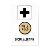 Round cream enamel pin that reads WELL READ in sans serif font on a Social Alert Pin backing card.