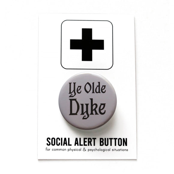 Round gray pinback button that reads YE OLD DYKE in a black old English front. Badge is on a Social Alert Button backing card.