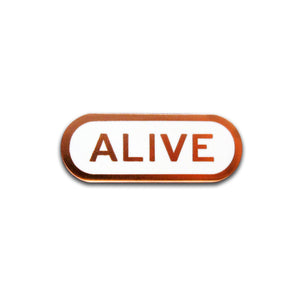 Capsule shaped enamel pin that says ALIVE.  Copper text and outline on a white enamel background
