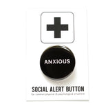 Black round pinback button that reads ANXIOUS in a white jittery font.