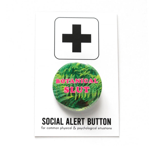 Round pinback button that says BOTANICAL SLUT. Pink text on a fern photo background