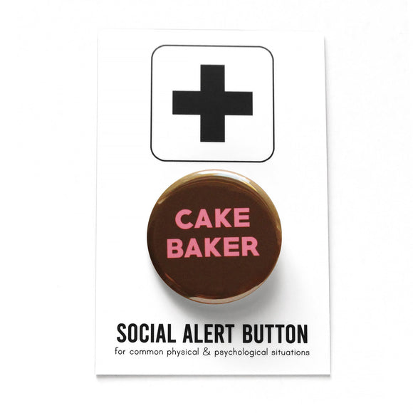Round chocolate brown pinback button that reads Cake Baker in medium pink san serif font. Pinback button is on Social Alert Button Backing Card