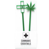 Two green acrylic, laser cut drink stirrers.  One is topped with a green cross that says CBD in the middle, the other is topped with a pot leaf.  