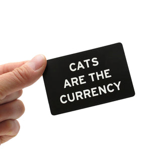 Rectangle sticker that says CATS ARE THE CURRENCY.  White text on a black background.