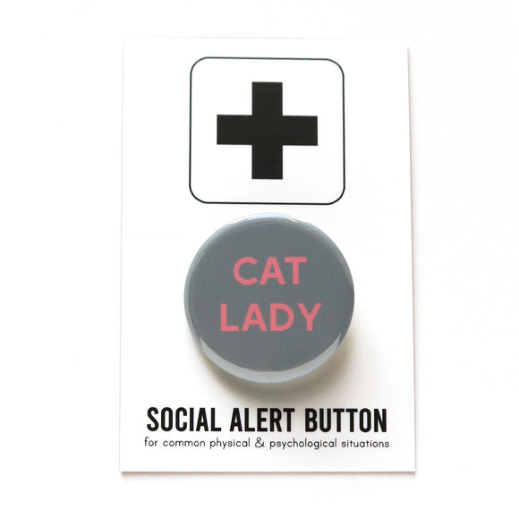 Round gray pinback button that says CAT LADY in pink text. Button is on a Social Alert Button backing card.