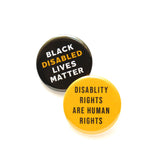 Two round pinback buttons on a white background. One button is black with whites san serif text that reads Black Disabled Lives Matter, Disabled is in golden-yellow.  Second button is golden yellow reads: Disability Rights are Human Rights in black sans serif text.