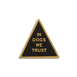 Triangle shaped hard enamel pin that says IN DOGS WE TRUST.  Gold text and outline on a black enamel background.