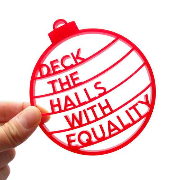 Laser cut festive red laser cut acrylic holiday ornament that reads, DECK THE HALLS WITH EQUALITY. Ornament is the shape of a classic round xmas ornament with stripes, and each stripe contains a word to spell out the full phrase.