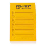 Lined notepad that reads FEMINIST WITH A TO-DO LIST at the top in black text. The paper is goldenrod yellow color. Checkboxes to the left, lines to write to-do list, to the right.