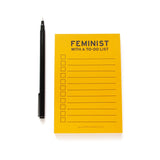 Lined notepad with checkboxes that says  FEMINIST WITH A TO-DO LIST at the top in black text.   The paper is goldenrod yellow color.