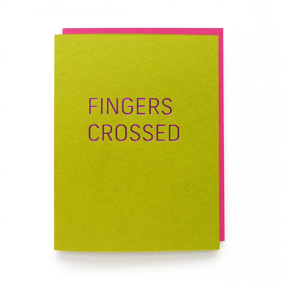 Rich lime green greeting card with magenta hot foil emboss that reads FINGERS CROSSED in a thin sans serif font. With Deep pink matching envelope.