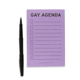 Lined lavender notepad with checkboxes on the left side, and lines to write your to-do's to the right. The top of the notepad reads: GAY AGENDA  in bold sans serif  black text. A black felt tip pen is uncapped and standing alert on the left side of the notepad, ready to write the list.