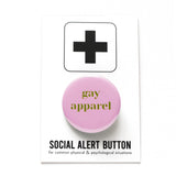 Pale pink round pinback button that reads GAY APPAREL in moss green serif text.  Button is on a Social Alert Button backing card.
