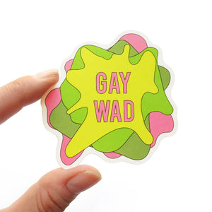 Sticker that says GAY WAD in pink letters.  The shape is like four layers of smashed gum on top of each other.