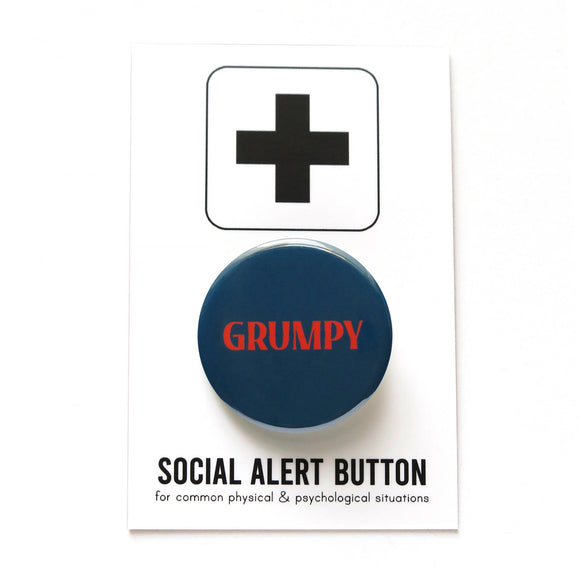 Dark navy blue round pinback button that reads GRUMPY in a red-orange font. Button is on a Social Alert Button backing card.