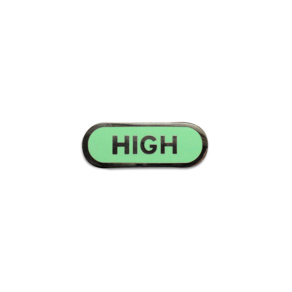 Capsule shaped enamel pin that says HIGH.  Silver text and outline on a mint green enamel background.