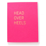 Magenta greeting card with gold, hot foil pressed text, that says HEAD OVER HEELS