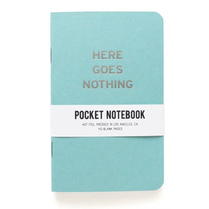 Light blue pocket notebook that says HERE GOES NOTHING in silver text.