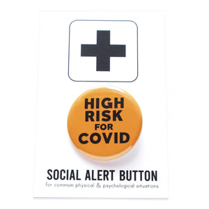 Round pinback button that says HIGH RISK FOR COVID.  Button is neon orange with black text. The button is on a black and white Social Alert Button backing card with a black plus sign at the top.