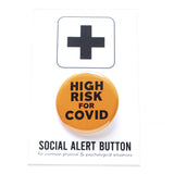Round pinback button that says HIGH RISK FOR COVID.  Button is neon orange with black text. The button is on a black and white Social Alert Button backing card with a black plus sign at the top.