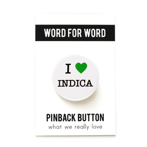 Round pinback button on a white background that says I LOVE INDICA. Love is depicted by a green heart. The other text is black.