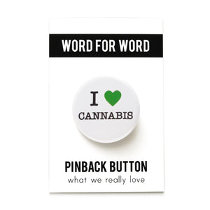 Round white button reads I LOVE CANNABIS. Green heart symbol represents love, remaining text is in black. Button is on a Word For Word branded backing card.