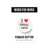 Round white pinback button that reads I Love Feral Cats. Love is represented by a red heart. Remaining text is in black font. Button is on a Word for Word backing card.