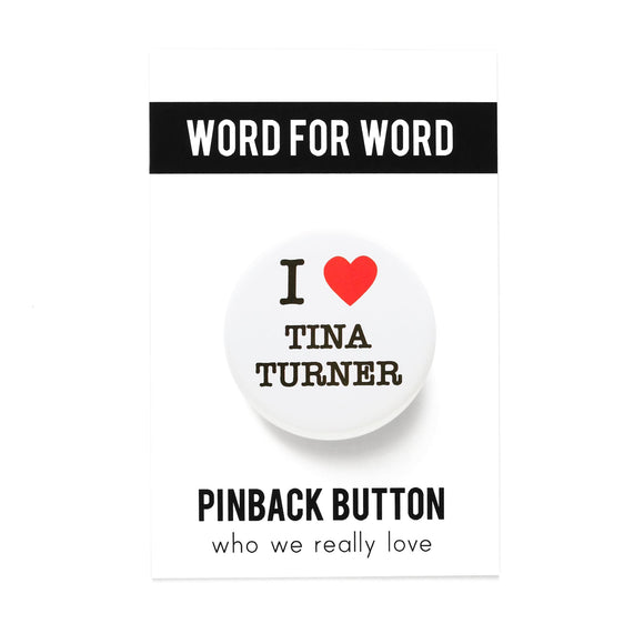 Round white pinback button with black serif test and a red heart. Text reads: I heart Tina Turner. Button is on a WORD FOR WORD pinback button backing card, on a white background