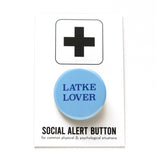 Light blue round pinback button that reads LATKE LOVER in dark blue serif text.  Button is on a Social Alert Button backing card.