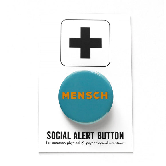 Round blue teal pinback button that reads MENSCH in yellow san serif font. Pinback button is on Social Alert Button Backing Card