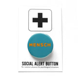 Round blue teal pinback button that reads MENSCH in yellow san serif font. Pinback button is on Social Alert Button Backing Card