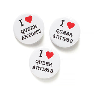 Three round white pinback buttons that reads I LOVE QUEER ARTISTS in a black serif font, the love being indicated by a red heart. 