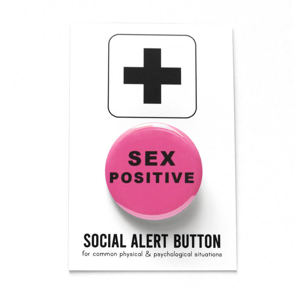 Round medium pink pinback button that reads SEX POSITIVE in a thick black san serif font. Pinback button is on Social Alert Button Backing Card