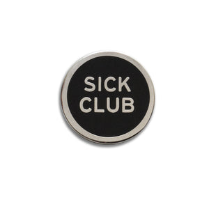 Round enamel pin that says SICK CLUB. Silver text and outline on a black background.