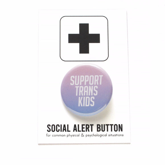 Round pinback button that says SUPPORT TRANS KIDS. Button is an ombre gradient of light pink to light blue  with white san serif text. The button is on a black and white Social Alert Button backing card with a black plus sign at the top.