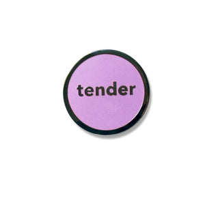 Round enamel pin that says TENDER. Silver text and outline with a lavender enamel background.