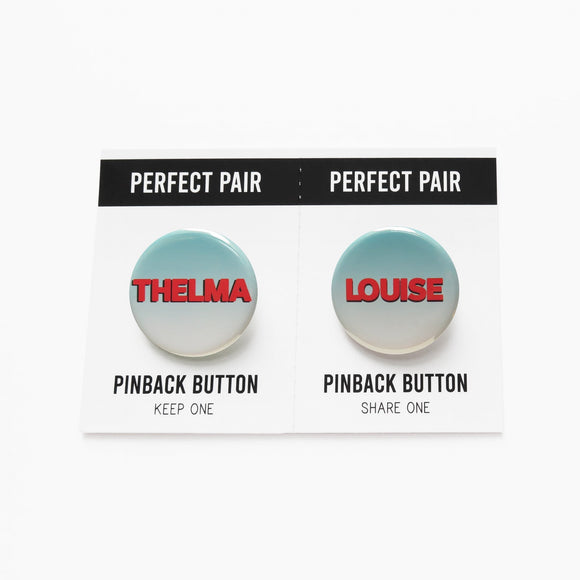 Two pinback buttons separated by a perforated line to tear & share. Button the left reads THELMA, button on the right reads LOUISE. Both buttons have a pale teal to white ombre with red text.