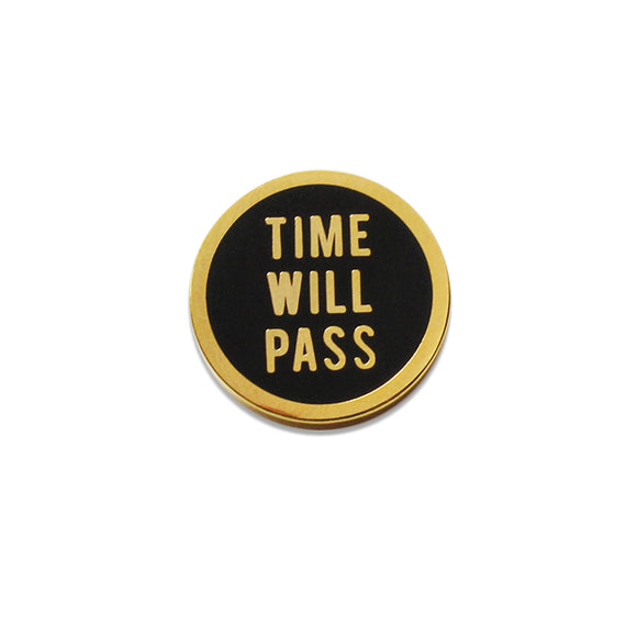 Round enamel pin that says TIME WILL PASS. Gold text and outline on a black background.