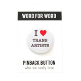 Round white pinback button with a bright read heart that reads I HEART TRANS ARTISTS in classic black type. Button is on a white backing card, with a black band at the top with WORD FOR WORD in white text. Below reads: PINBACK BUTTON, Who We Really Love.
