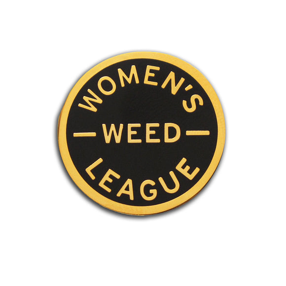 Round enamel pin that says WOMEN'S WEED LEAGUE. Gold text and outline on a black enamel background.